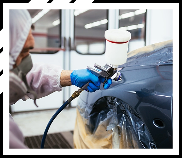 Car mechanic painting car dent