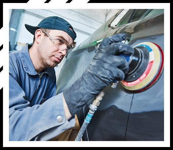 Mechanic repairing car dent